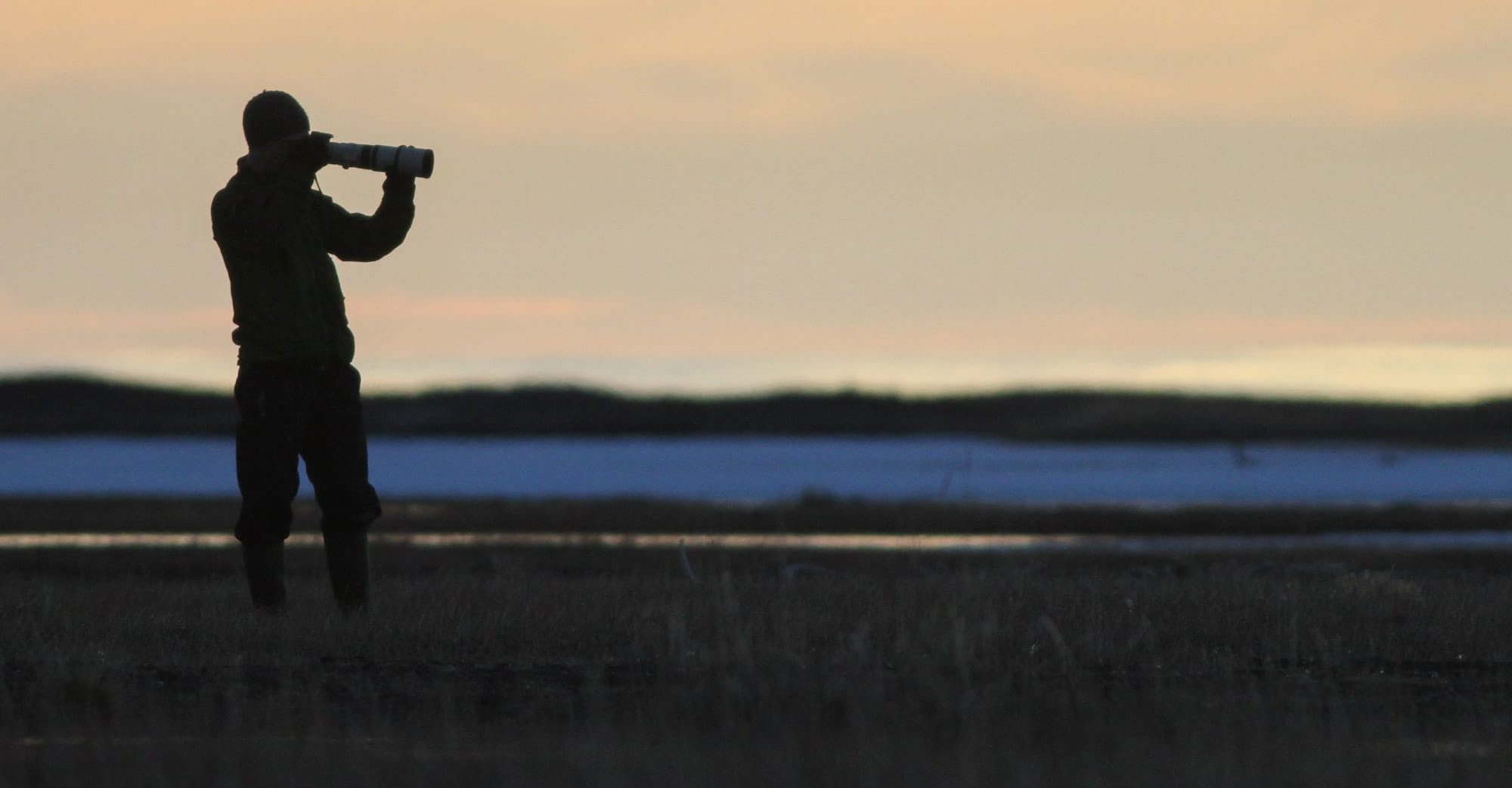 Man with camera at sunset in arctic